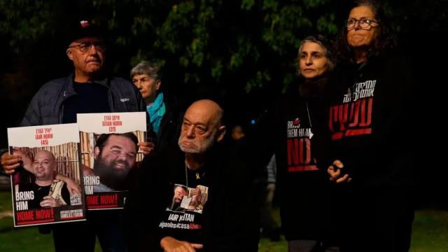Itzik Horn, acompañado de seres queridos y las fotografías de sus hijos secuestrados por Hamás.