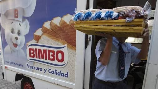 Un empleado de Bimbo llevando una bandeja de productos