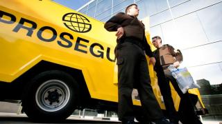 Empleados de Prosegur junto a una furgoneta de la empresa