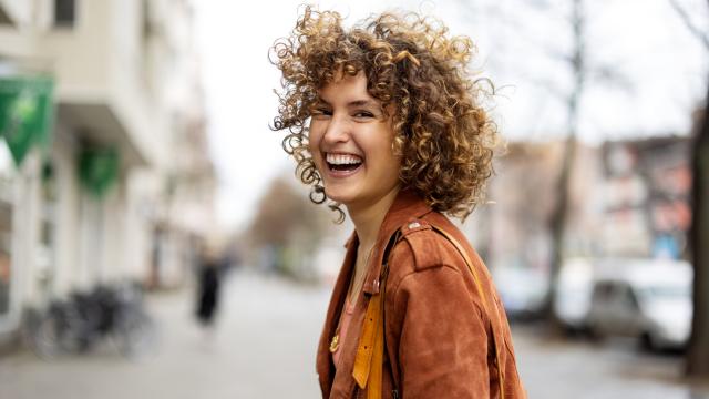 Mujer feliz paseando por la calle.