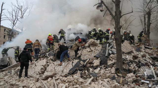 Bomberos y vecinos de Járkov en medio de los escombros provocados por los bombardeos rusos.