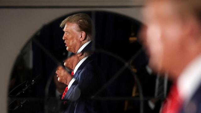 El reflejo de Donald Trump durante un mitin previo a las primarias de Nuevo Hampshire.
