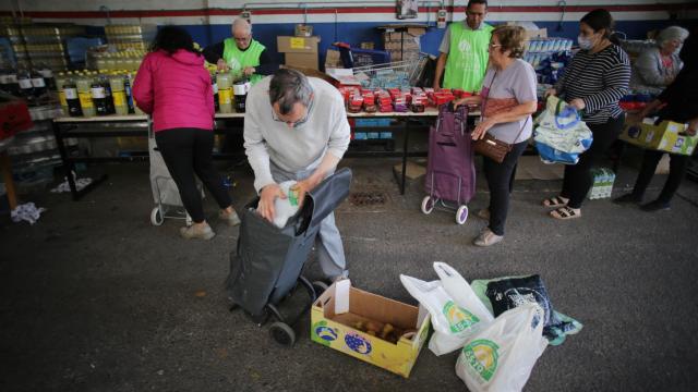 Unas personas recogen comida en un Banco de Alimentos, en Lugo.