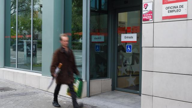 Una persona pasa al lado de una oficina del paro.