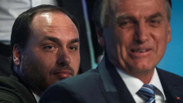 Jair Bolsonaro y su hijo Carlos asisten a un debate presidencial, en 2022 en Río de Janeiro.