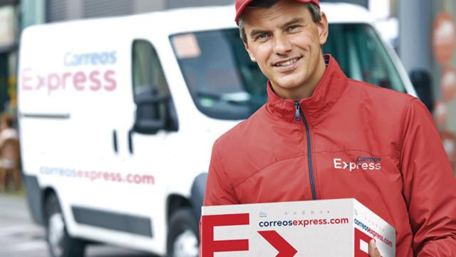 Un empleado de Correos Express junto a la furgoneta de la empresa