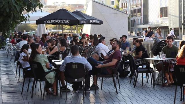 Un grupo de jóvenes en la terraza de un bar.