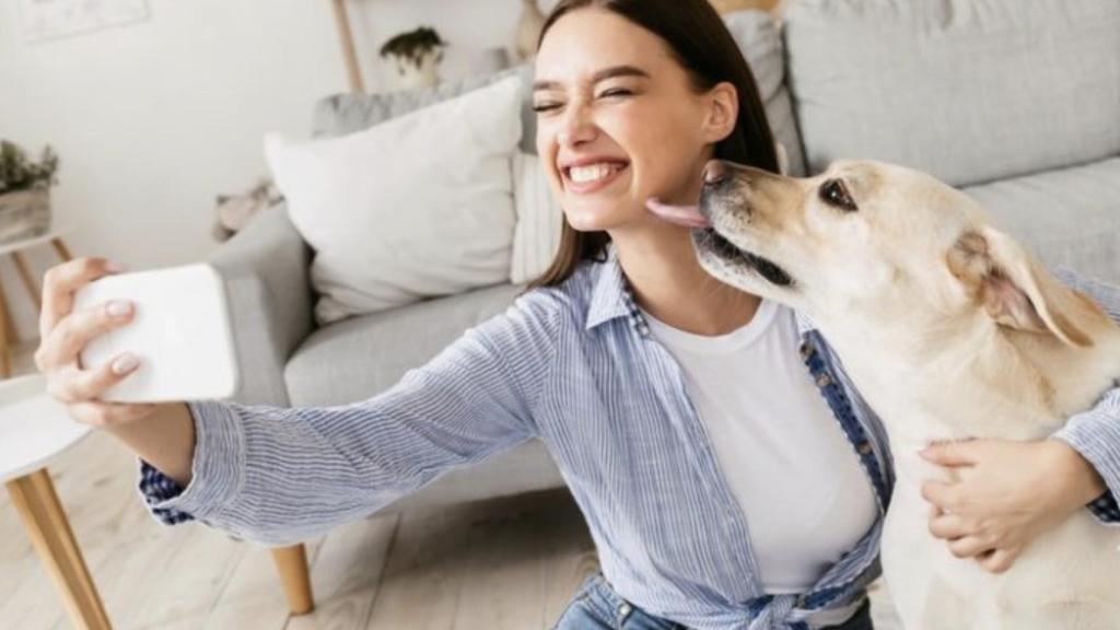Una mujer posando con su perro.