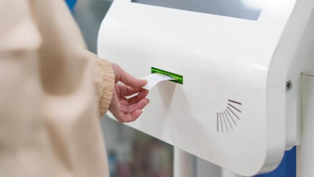Una persona sacando cita en un expendedor