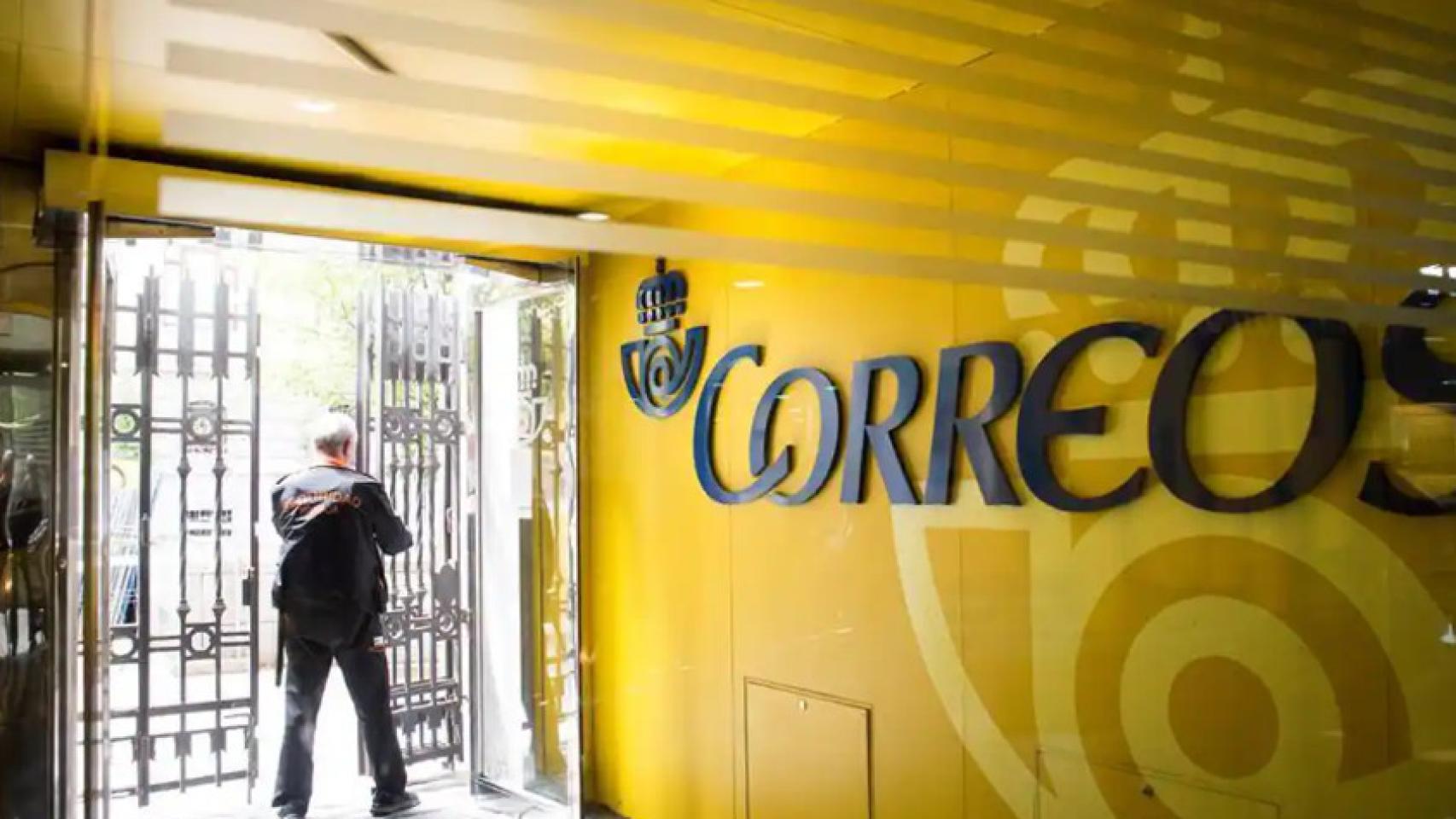 Un operario de seguridad cerrando una oficina de Correos.