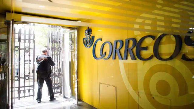 Un operario de seguridad cerrando una oficina de Correos
