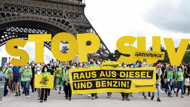 Montaje realizado con una manifestación contra los SUV en Alemania con la torre Eiffel de fondo.