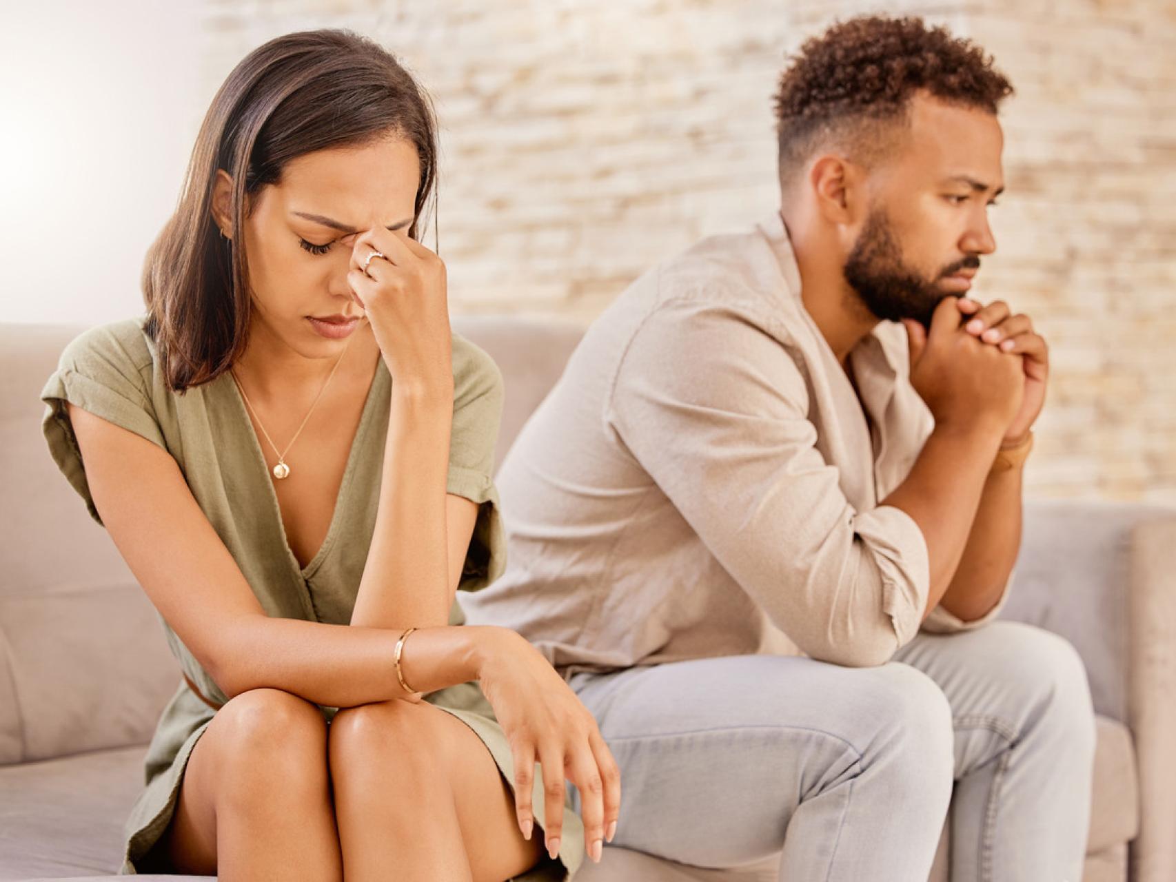 Una pareja en la cama y ella le oculta su móvil.