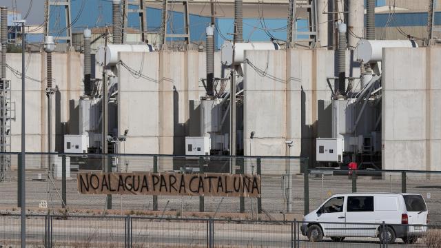 Imagen de la desaladora de Sagunto, con una pancarta en la que puede leerse No al agua para Cataluña