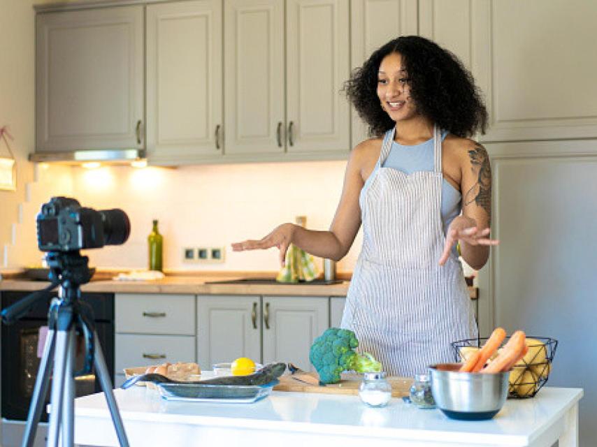 Una mujer grabándose en su cocina.