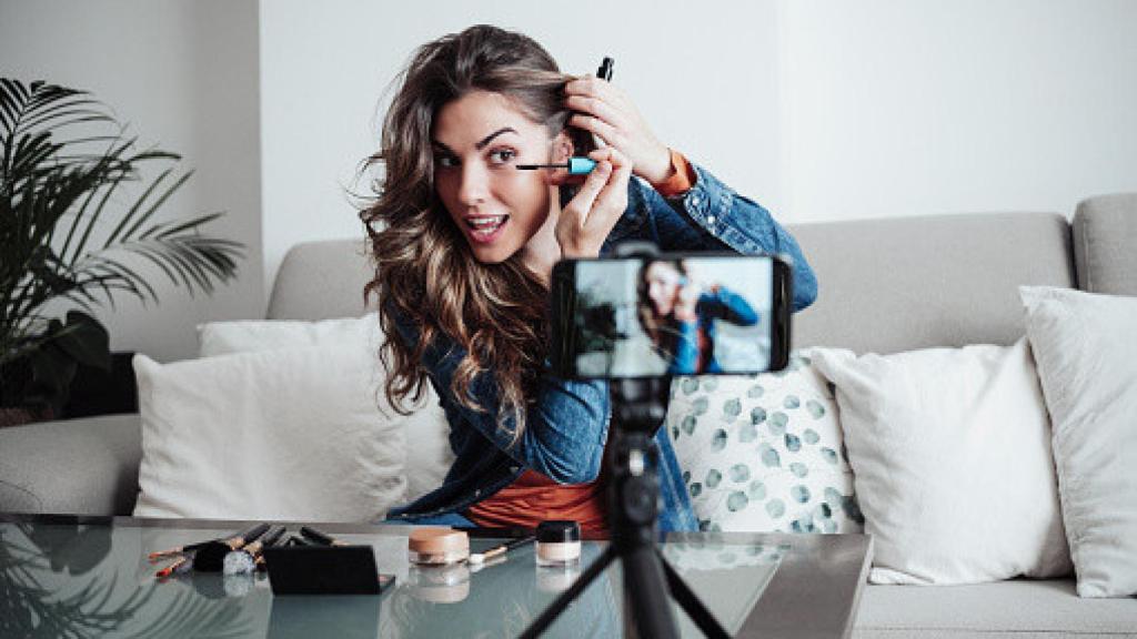 Una mujer grabando un vídeo maquillándose.