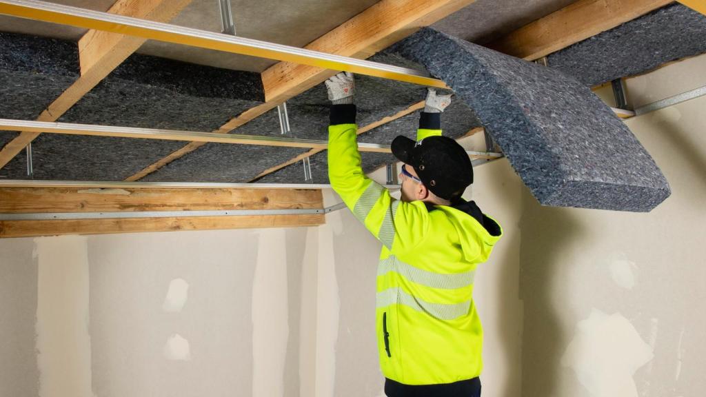 Un operario instalando paneles Isocoton en un techo