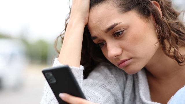 Imagen de archivo de una persona afectada por una información en su teléfono móvil.