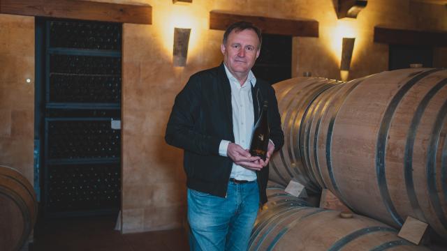 El bodeguero Hilario García, sujetando una botella de AurumRed en el interior de su bodega, situada en Las Pedroñeras (Cuenca).