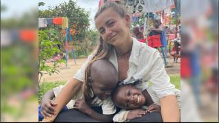 María Galán, junto a dos niños de uno de los tres orfanatos en los que colabora BabiesUganda.
