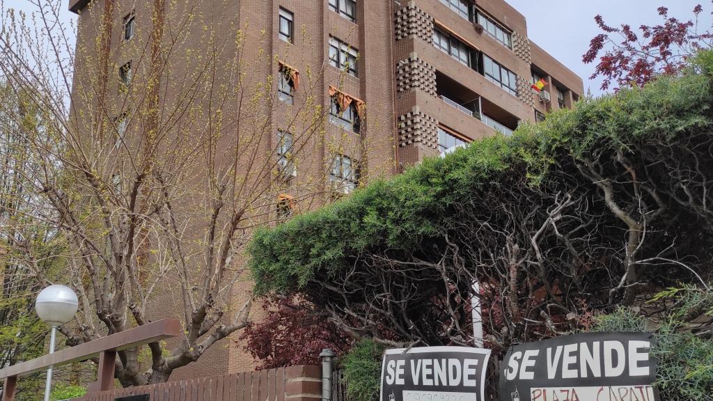 Edificio de viviendas con un cartel de 'se vende'.