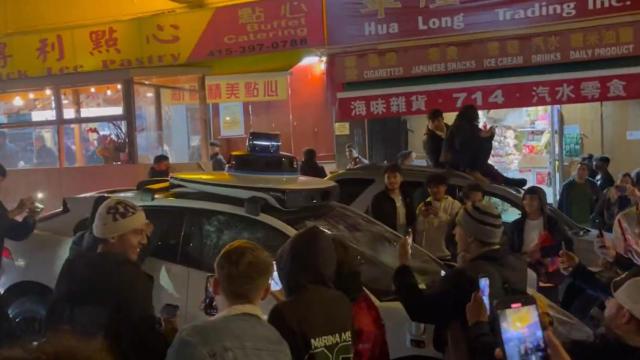 Multitud destrozando un coche Waymo en San Francisco