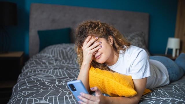 Una mujer mirando el móvil preocupada en su día libre.