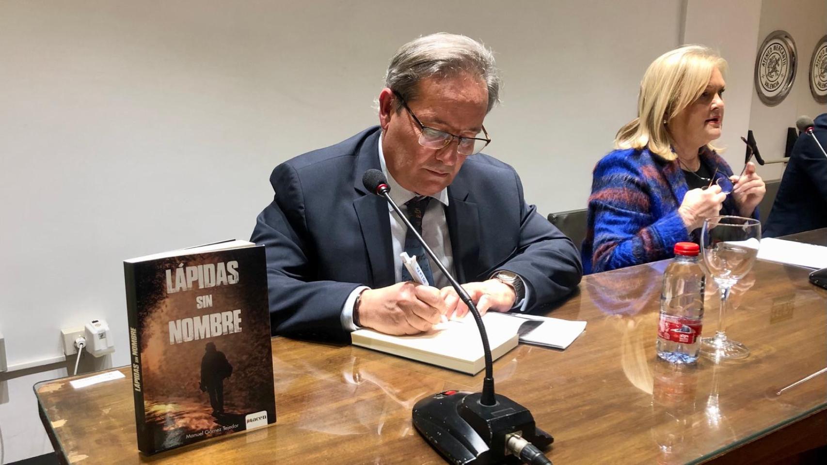 Manuel Gómez Tejedor firma un ejemplar de 'Lápidas sin nombre'. EE