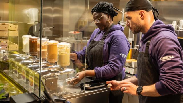 Astou y Mota en Chirusa, la 'chocolatería refugio' que colabora con CEAR en Madrid, preparando chocolate.