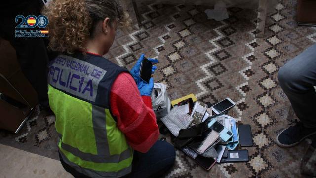 Una policía nacional con decenas de móviles durante uno de los registros practicados en enero.