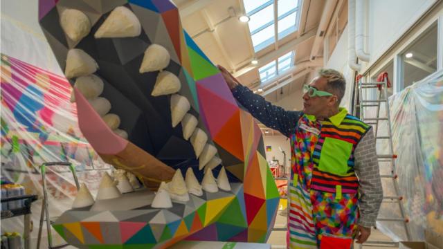 Okuda al lado del dragón chino que ha creado.