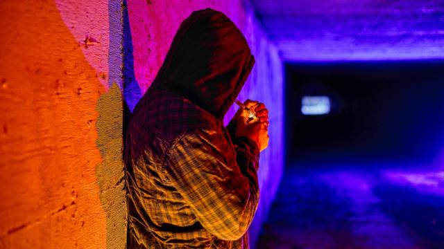 Un hombre se enciende un porro en un túnel.