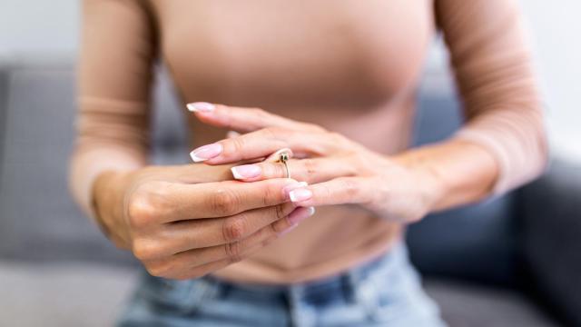 Mujer quitándose el anillo de casada