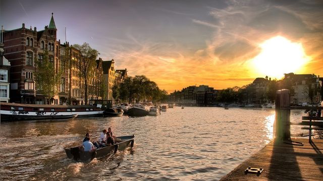 Varias personas navegando por los canales de Ámsterdam