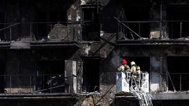 Bomberos inspeccionan el exterior del edificio tras el incendio