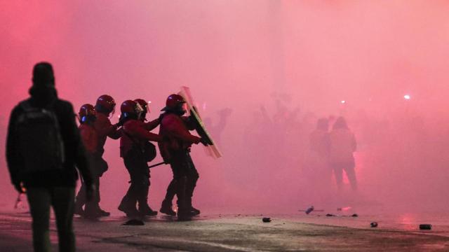 Varios agentes de la Ertzaintza se protegen ante el lanzamiento de objetos en la entrada del estadio San Mamés.