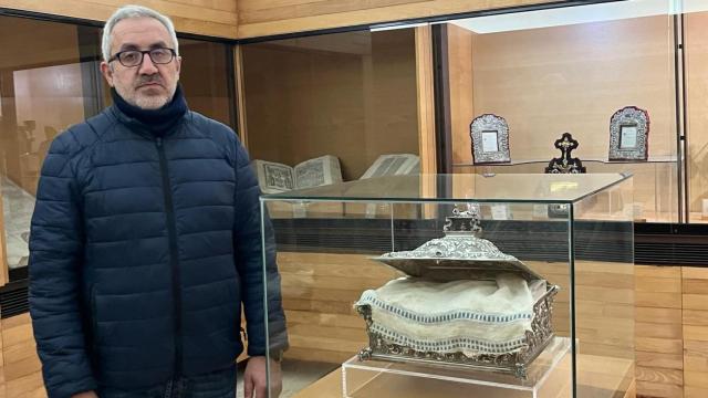 Óscar García, junto al  mantel, en la urna del siglo XVIII en la que se guarda en el Museo de la Catedral de Coria.