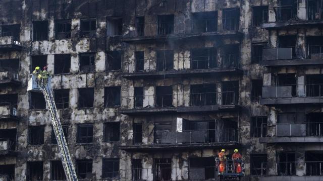 Los bomberos trabajan en el edificio incendiado en Valencia.