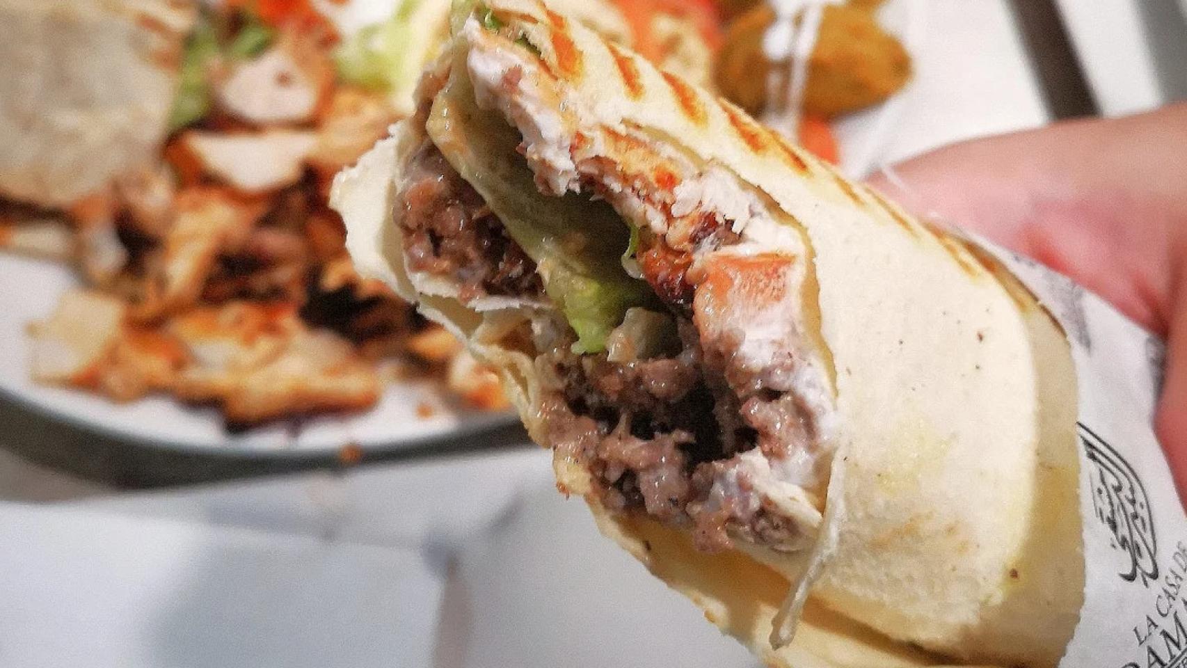 Una persona sosteniendo un kebab.