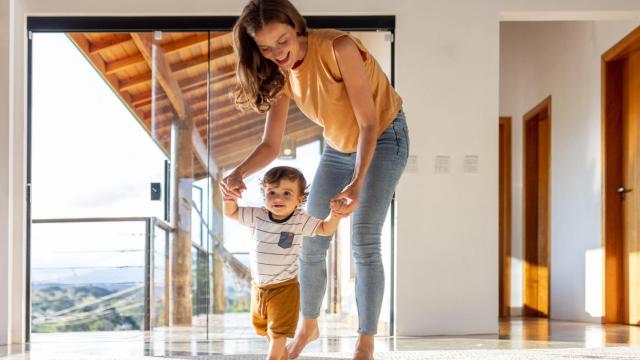 Imagen de archivo de un niño aprendiendo a caminar con ayuda de su madre (iStock).
