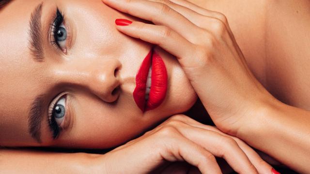 Mujer de ojos azules con la mano en la cara.