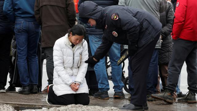 Un policía se acerca a una mujer fuera del Crocus City Hall, este sábado en Moscú.