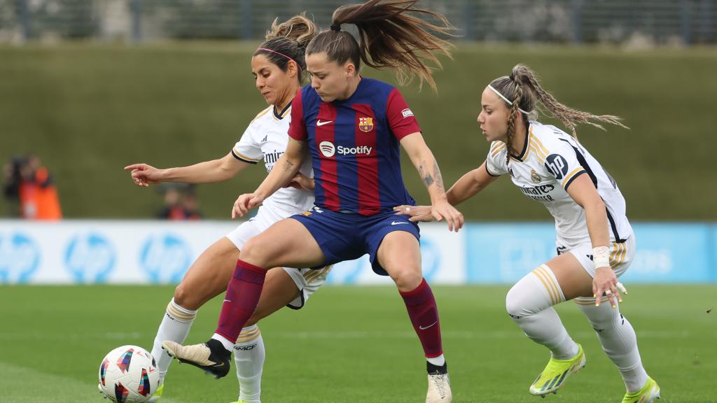 La defensa mexicana Kenti Robles (i) y la delantera Athenea del Castillo (d), ambas del Real Madrid, disputan el balón ante Claudia Pina (c), delantera del Barça.