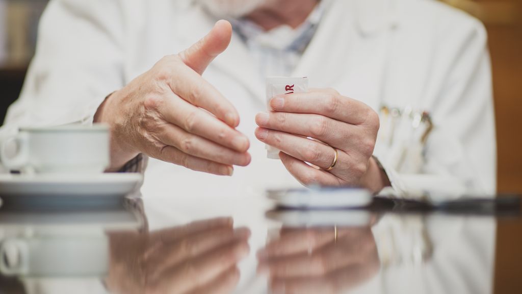 Detalle de las manos del doctor Cacabelos, que sostiene un sobre de azúcar durante la entrevista con EL ESPAÑOL | Porfolio.