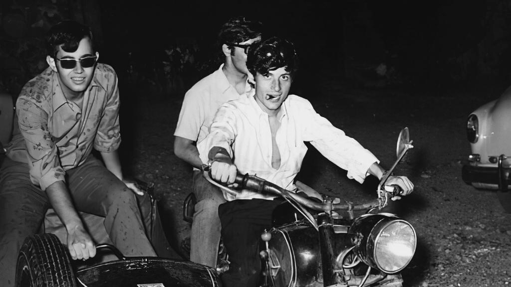 En la moto, Puig Antich, a los 23 años, en la boda de su hermana. Detrás de él, su amigo Xavier Garriga, también miembro del MIL