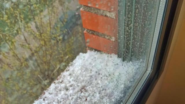 Granizo acumulado en el poyete de una ventana de un piso de Móstoles, este martes.