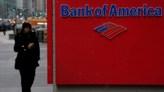 Una mujer camina por al lado de una sede de Bank of America.