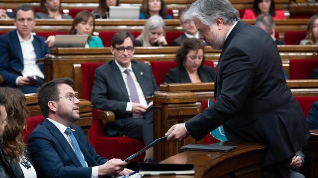 Salvador Illa, al fondo, observa al 'president', Pere Aragonès y a Albert Batet, líder de Junts, en el Parlament.