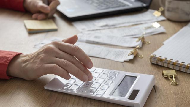 Una persona hace cuentas con una calculadora.