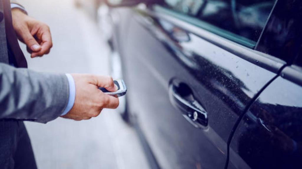 Una persona intentado abrir un coche con una llave